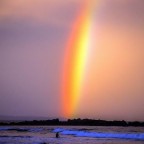 Arco bicolor aparece no céu de praia na Austrália